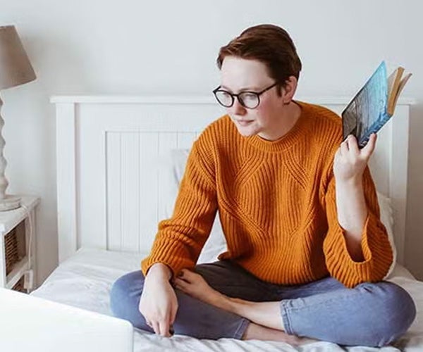 Professional studying property development using a laptop and textbook, representing flexible online learning.